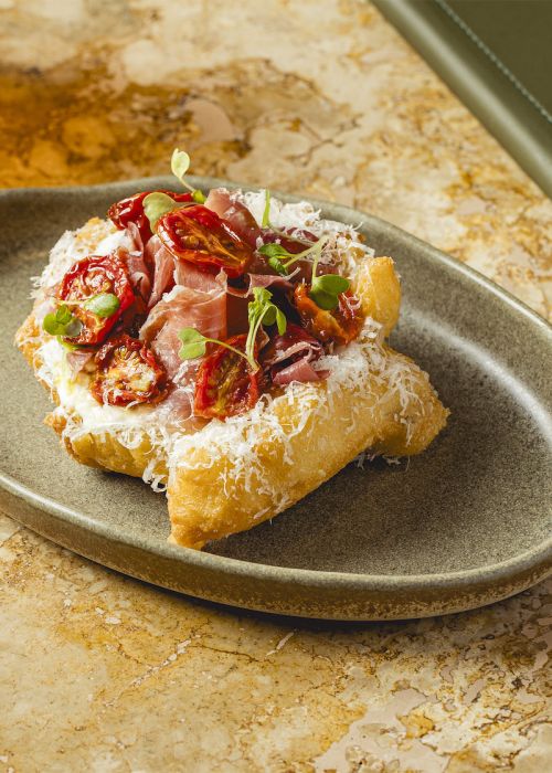Lángos with sour cream, cheese and aged ham